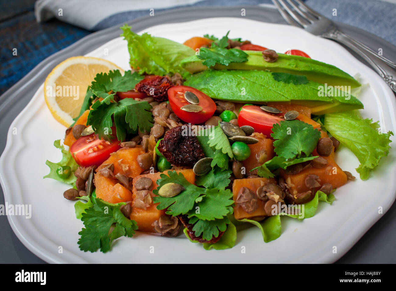 Salad with baked sweet potatoes, avocados, lentils, dried tomatoes, cilantro, pumpkin seeds and oil. .  Perfect for the detox diet or just a healthy m Stock Photo