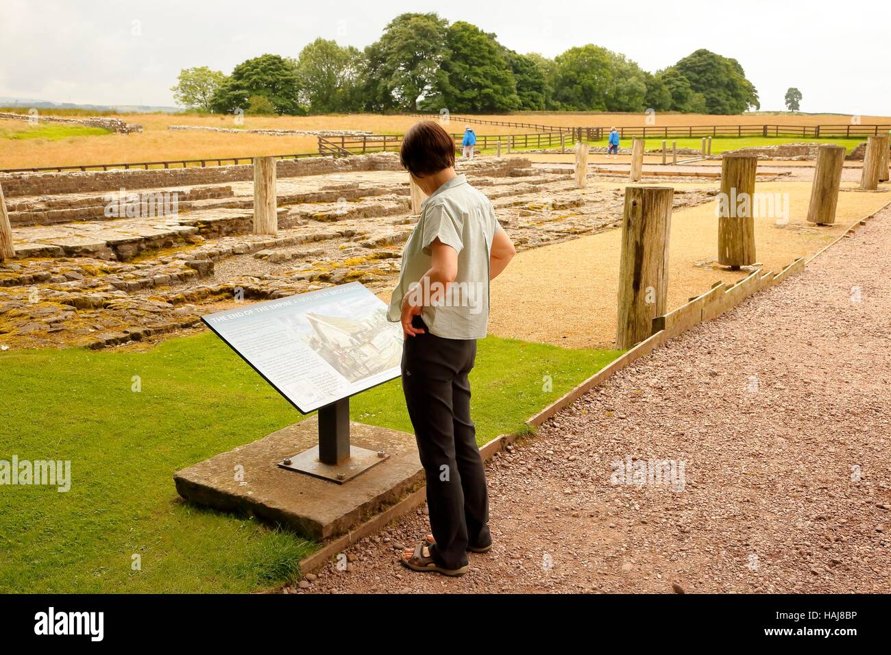 Woman reading information sign. Banna, Birdoswald Roman Fort, Cumbria, England, United Kingdom, Europe. Stock Photo