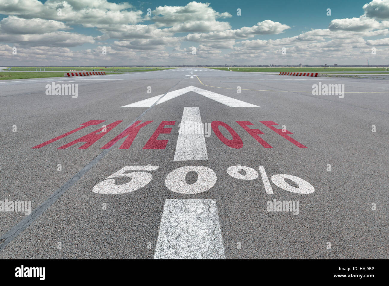 Runway of airport with arrow guideline, take off and 50 percent sign printed on the asphalt Stock Photo