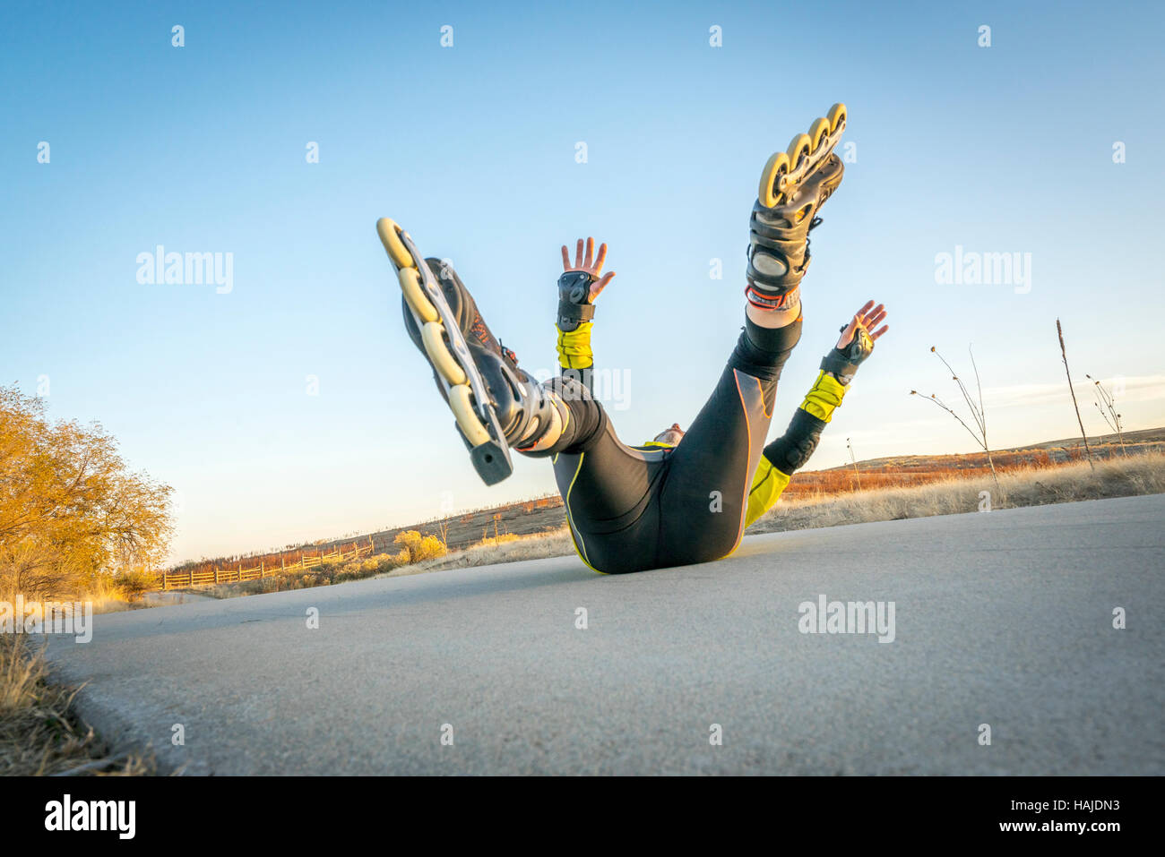 Inline skating accident male skater falling on concrete bike trail,l
