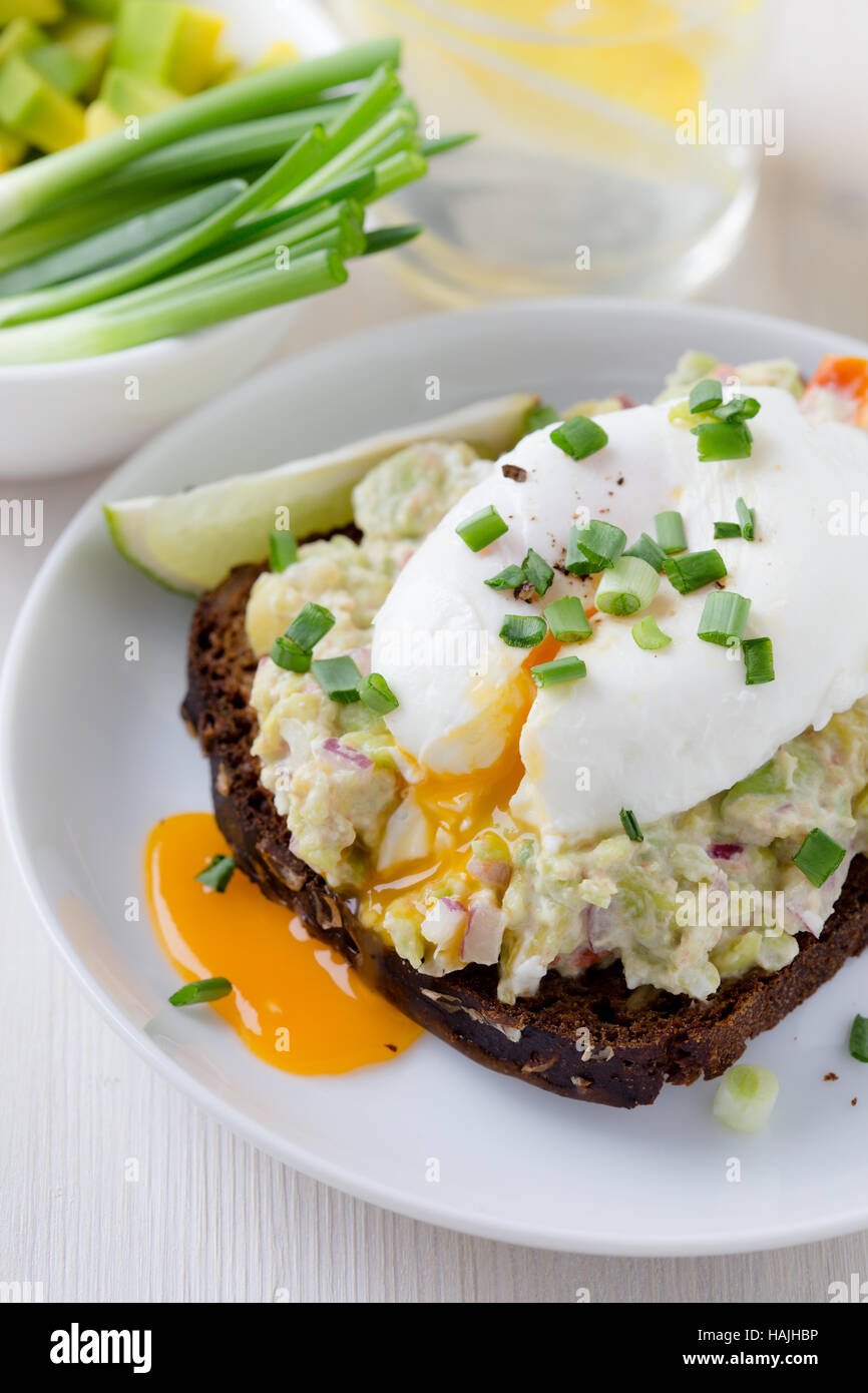 Avocado and feta smash on toasted rye bread and poached egg on top