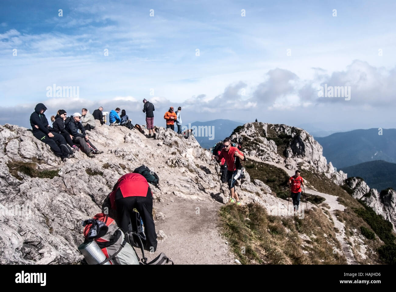 Velky Rozsutec hill summit in Mala Fatra mountains with relaxing hikers during autumn day with blue sky and clouds Stock Photo