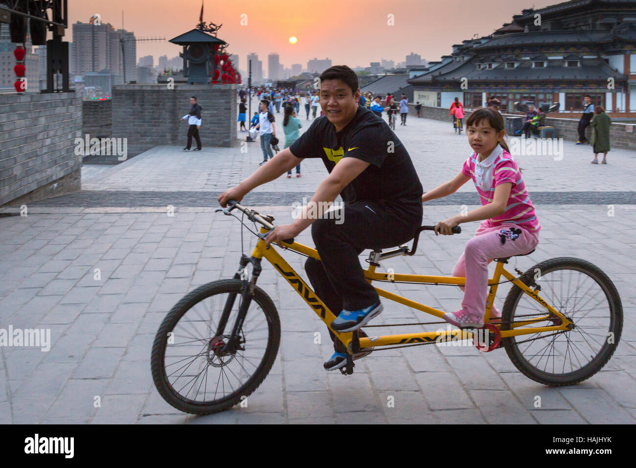 Tourists on bicycle on Xian city walls at sunset, Shaanxi province, China Stock Photo