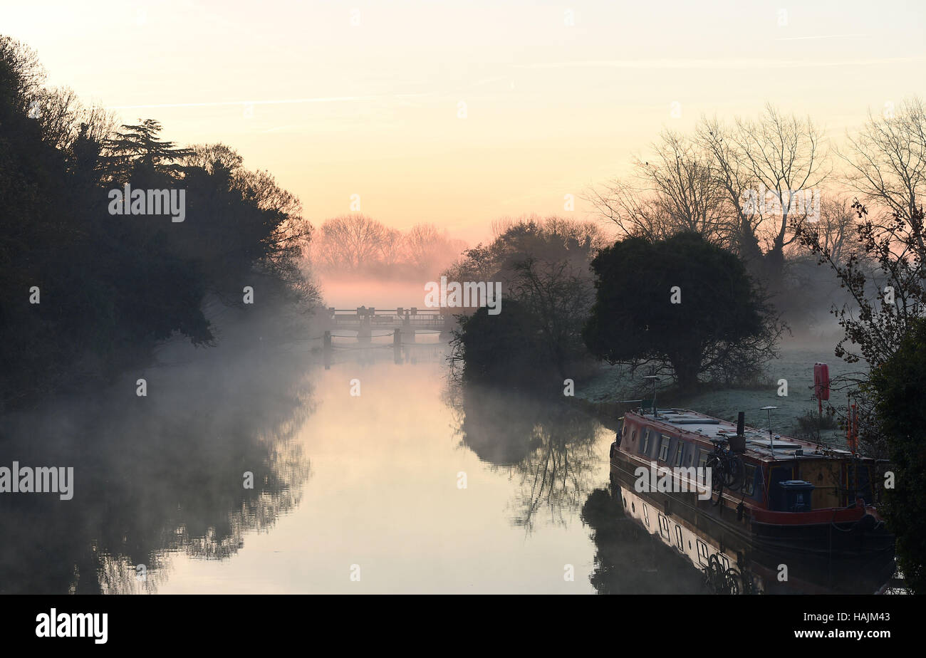 Mist and fog surround a canal boat at Godstow Lock in Oxfordshire, with today marking the official start of meteorological winter as temperatures again dropped below freezing again across large parts of England and Wales. Stock Photo
