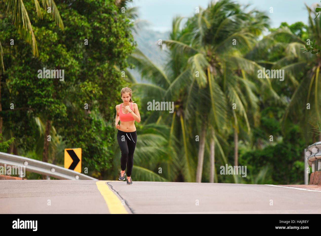 young fitness woman running at tropical forest trail Stock Photo - Alamy