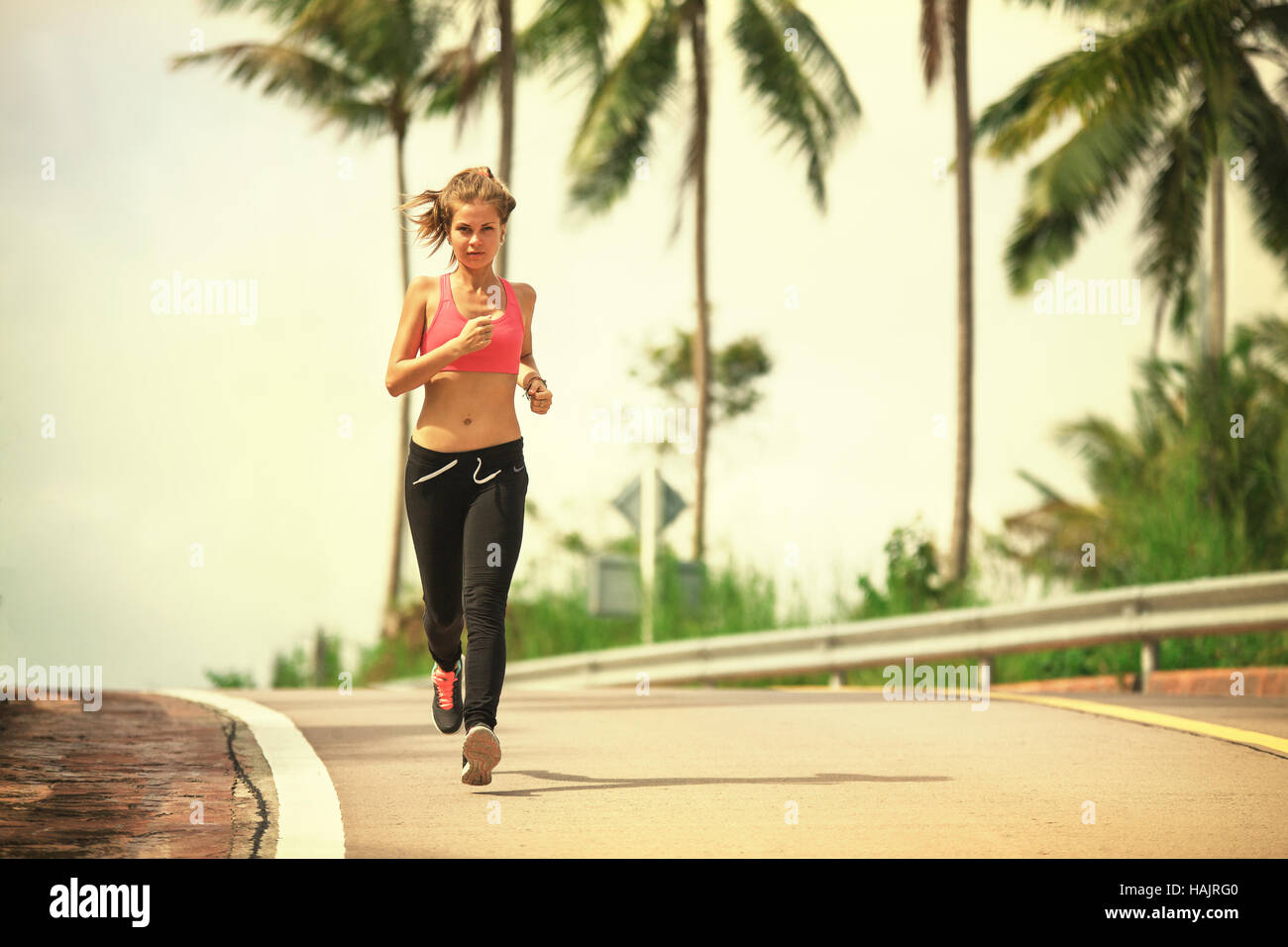 young fitness woman running at tropical forest trail Stock Photo - Alamy