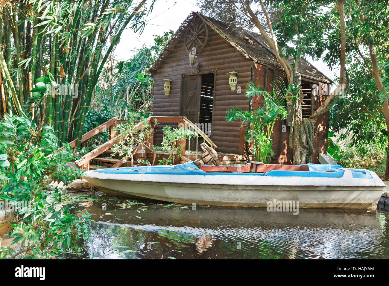 Boat on a pond on a background of a wooden house with bamboo Stock Photo