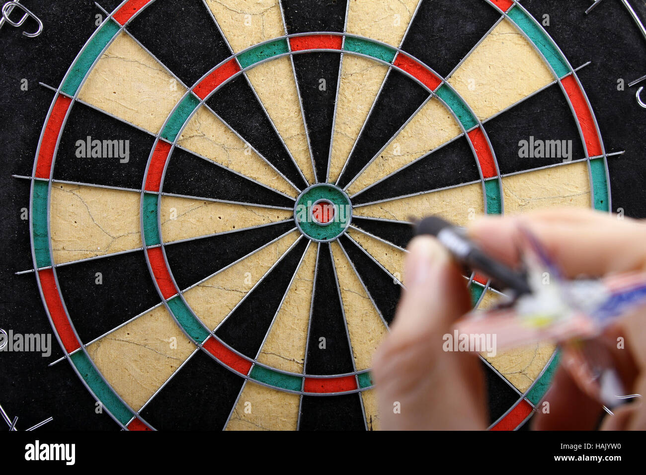 hand throwing dart to dartboard Stock Photo