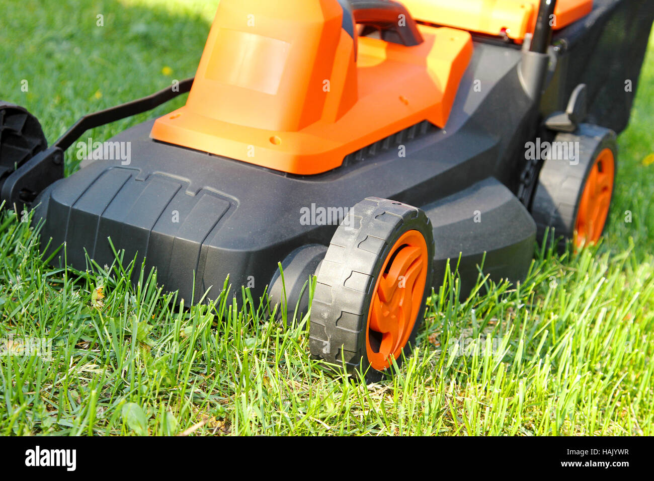closeup of electric lawnmower on green grass Stock Photo