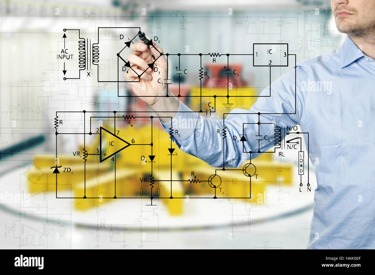 electrical engineer draws a diagram of a circuit. power plant interior in background Stock Photo