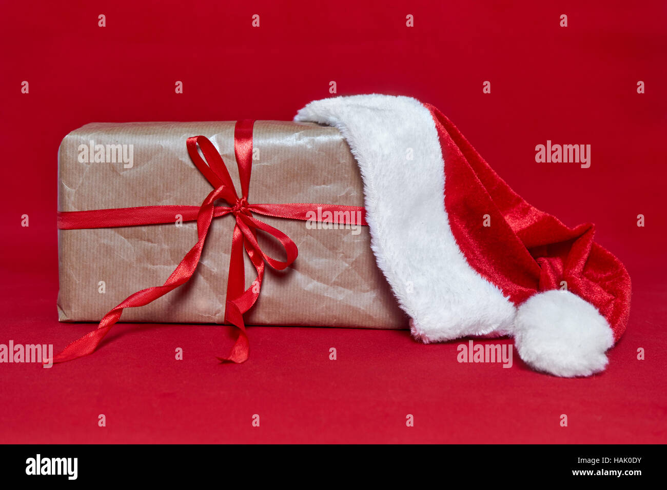 Box gift with Santa Claus hut on red background Stock Photo - Alamy