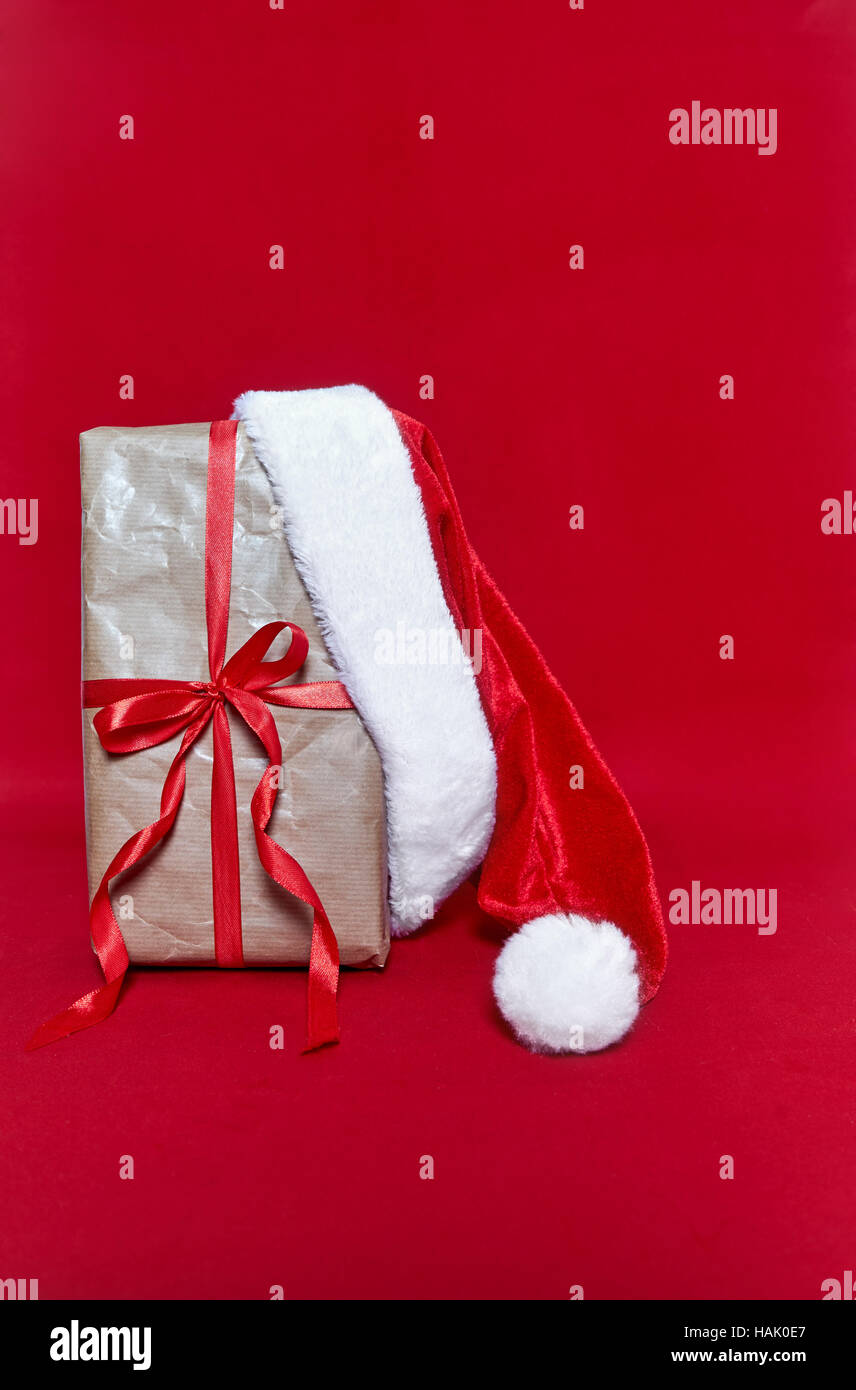 Box gift with Santa Claus hut on red background Stock Photo - Alamy