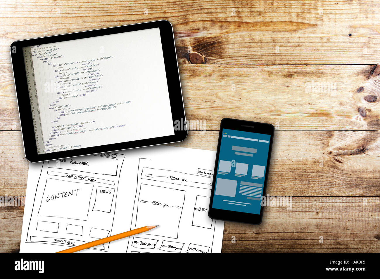 website wireframe sketch and programming code on digital tablet Stock Photo