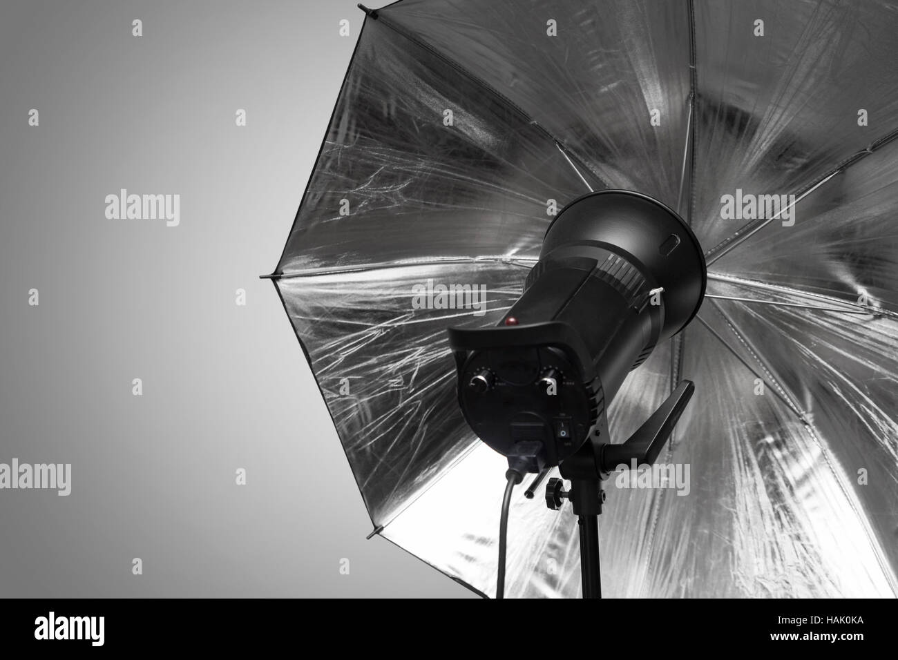 photography studio strobe flash with silver umbrella and gray copy