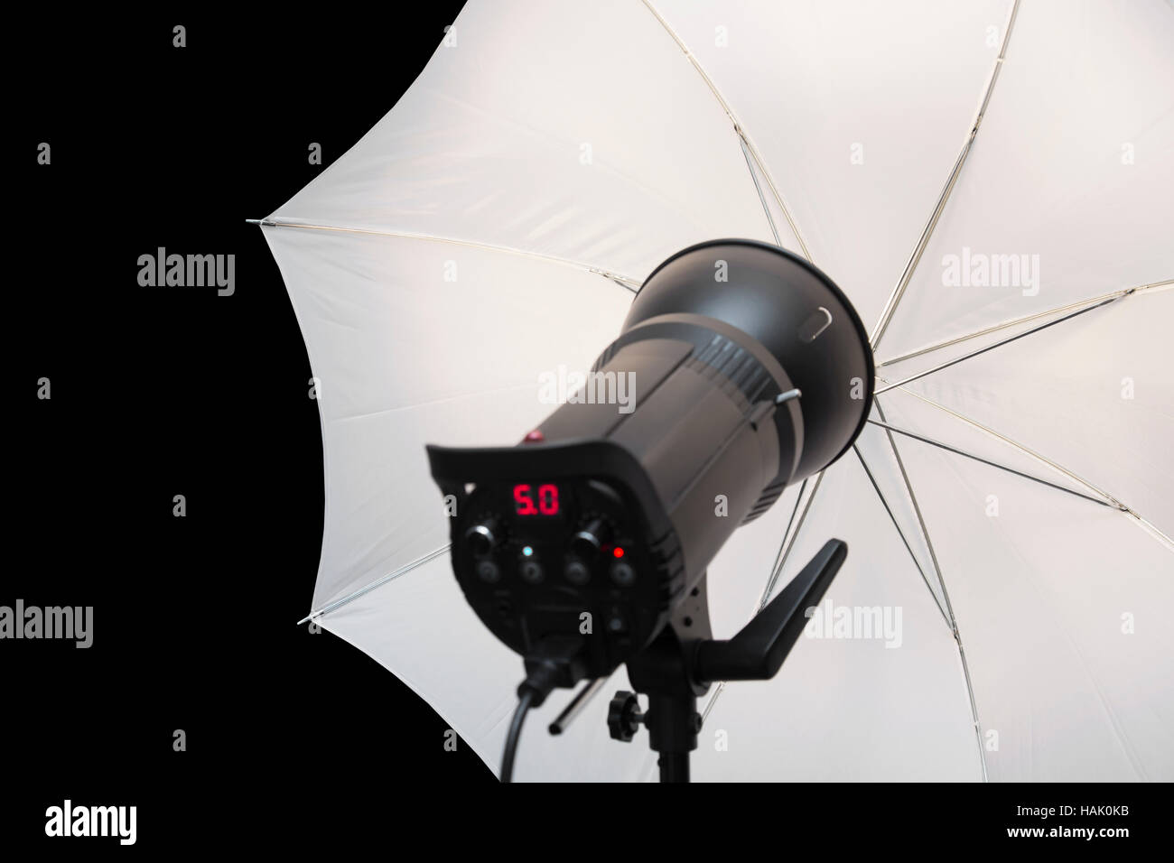 photography studio strobe flash with white umbrella and black copy space Stock Photo