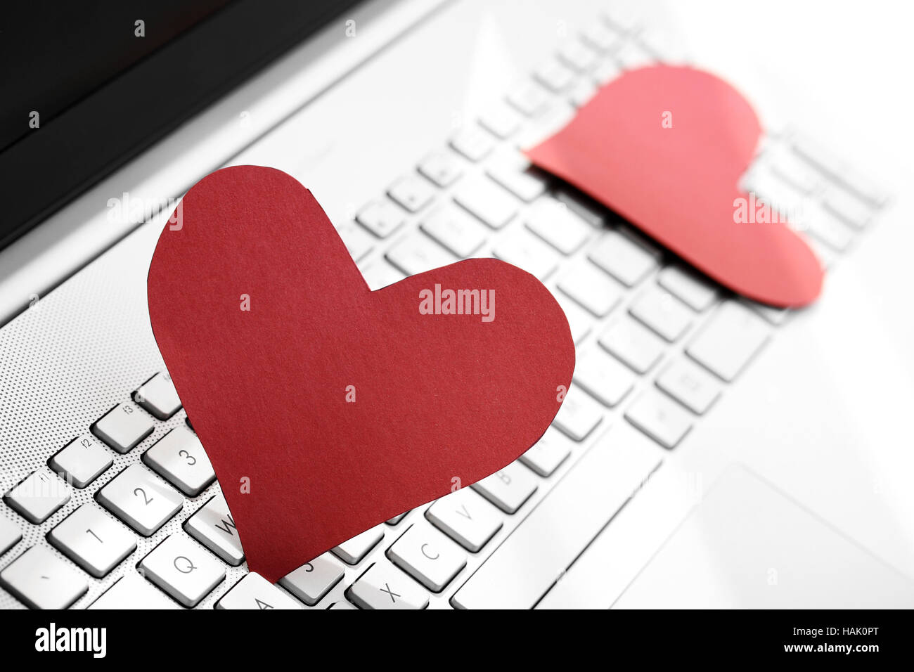 internet dating concept - two paper hearts on computer keyboard Stock Photo
