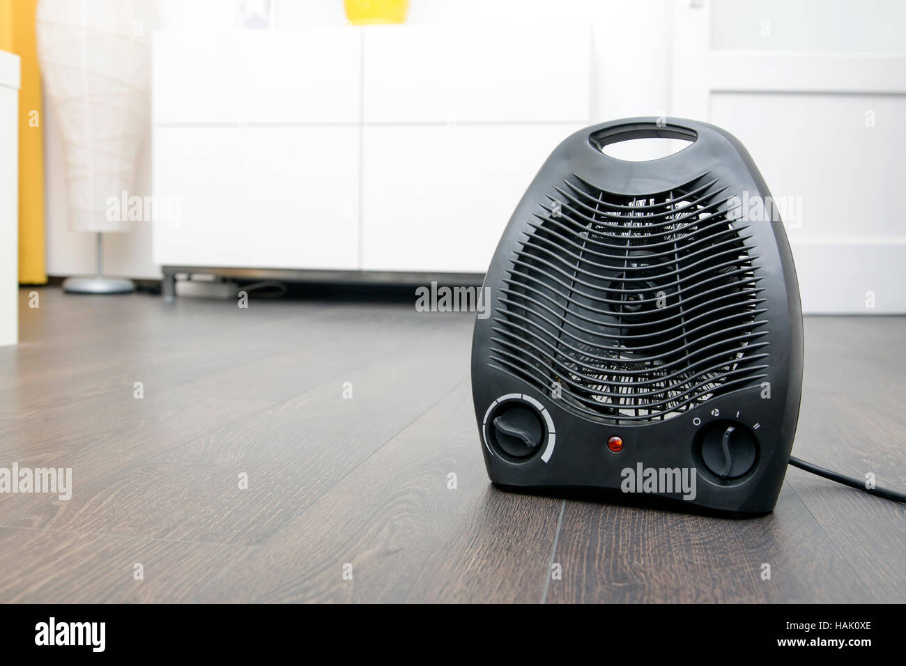 black electric heater on laminate floor in the room Stock Photo