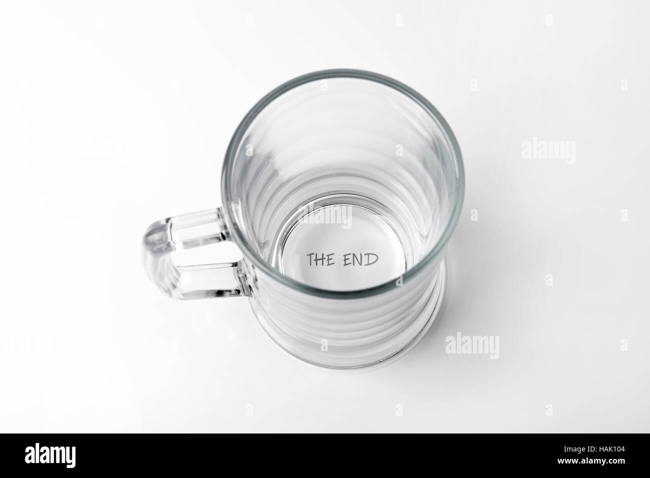 alcohol addiction concept - empty glass with 'the end' text on the bottom Stock Photo