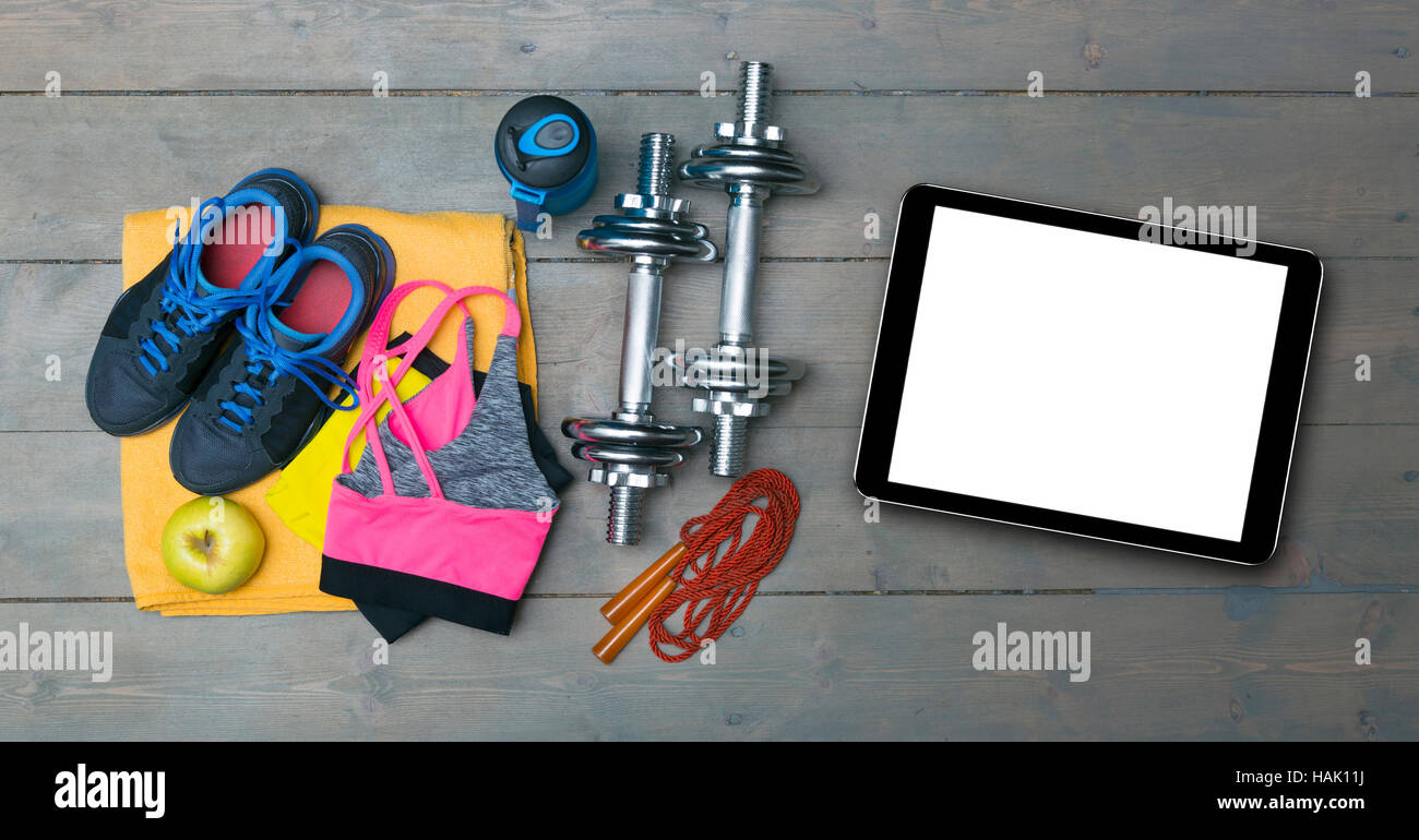 colorful fitness equipment and blank digital tablet on gym floor Stock Photo