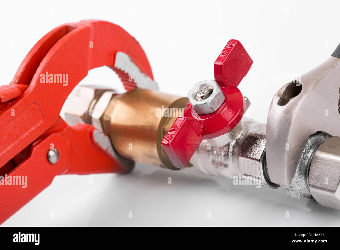 closeup of plumbing valve connection and pipe wrench Stock Photo