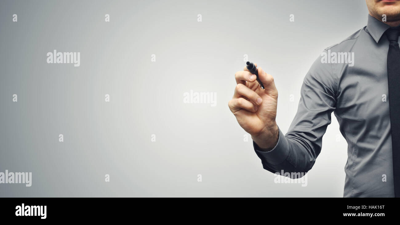 businessman with black marker on gray background with copy space Stock Photo