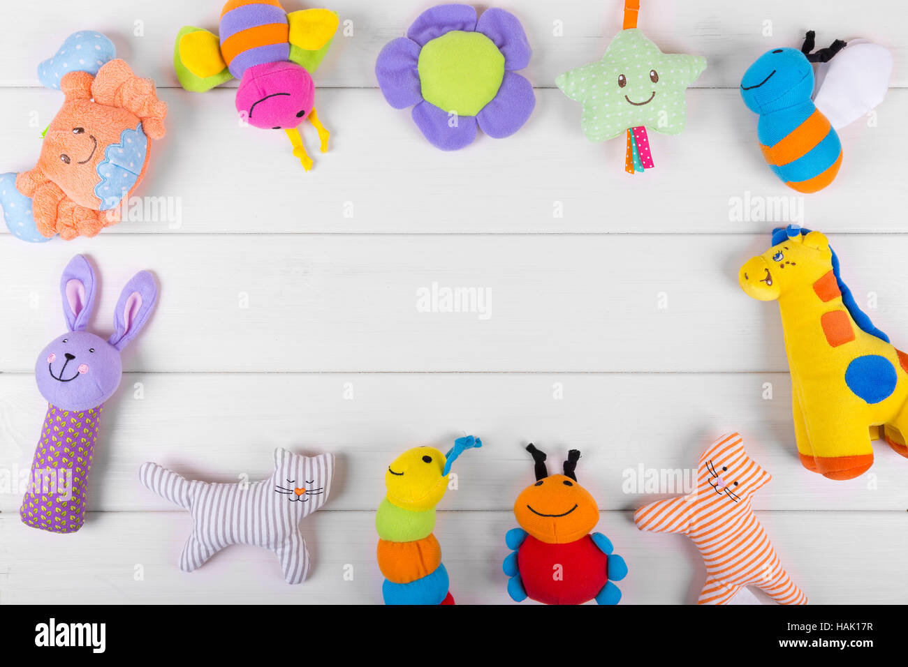 colorful soft baby toys on wooden background with copy space Stock Photo