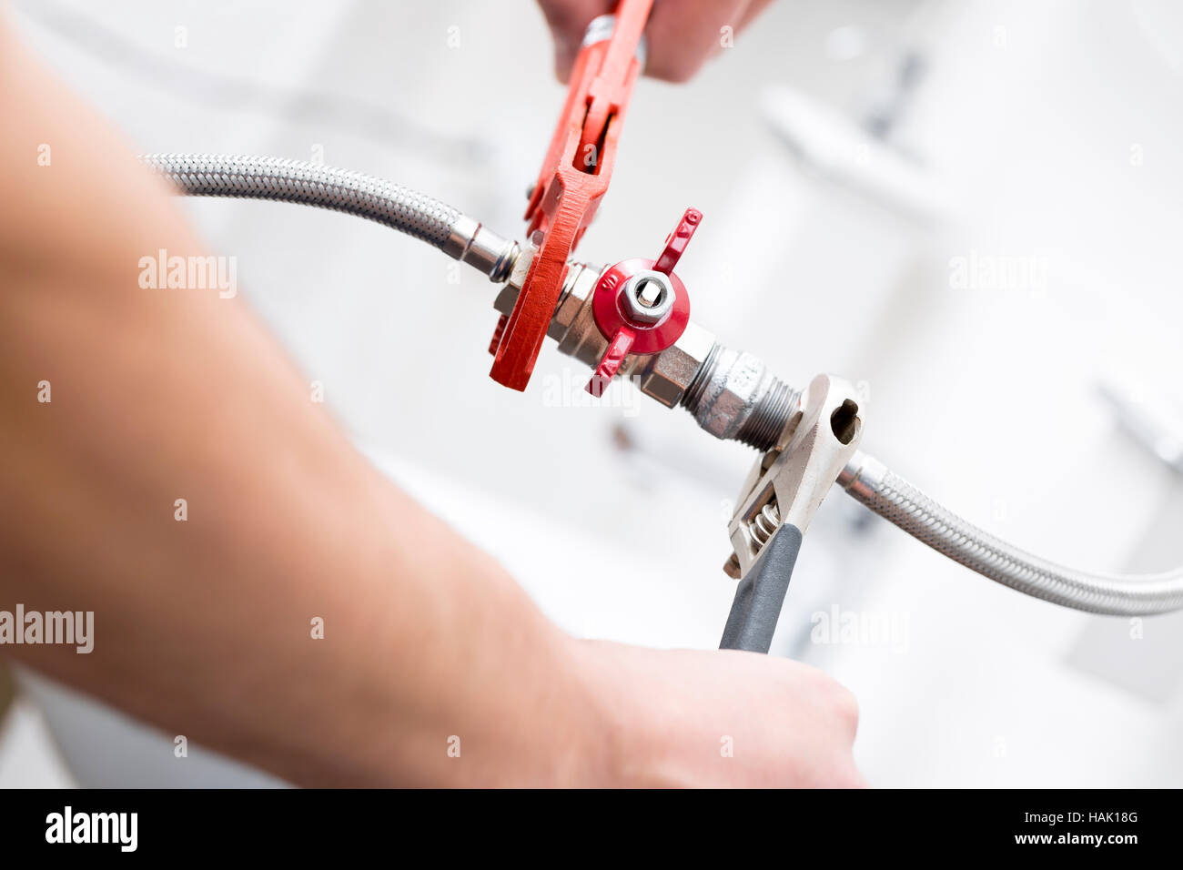 plumber screwing plumbing fittings in bathroom Stock Photo