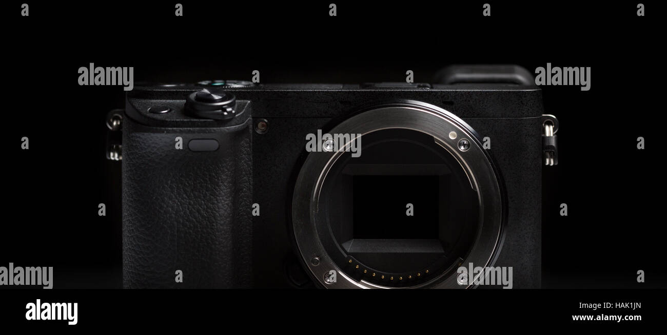 mirrorless camera body on dark black background Stock Photo