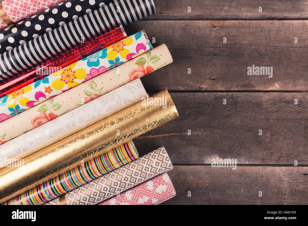 gift wrapping paper rolls on wooden table with copy space Stock Photo