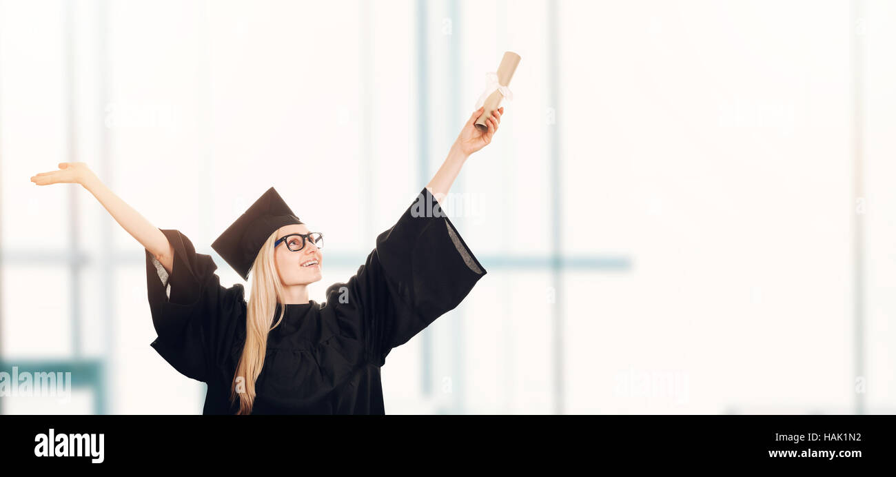 graduation - happy student in gown with diploma. copy space Stock Photo