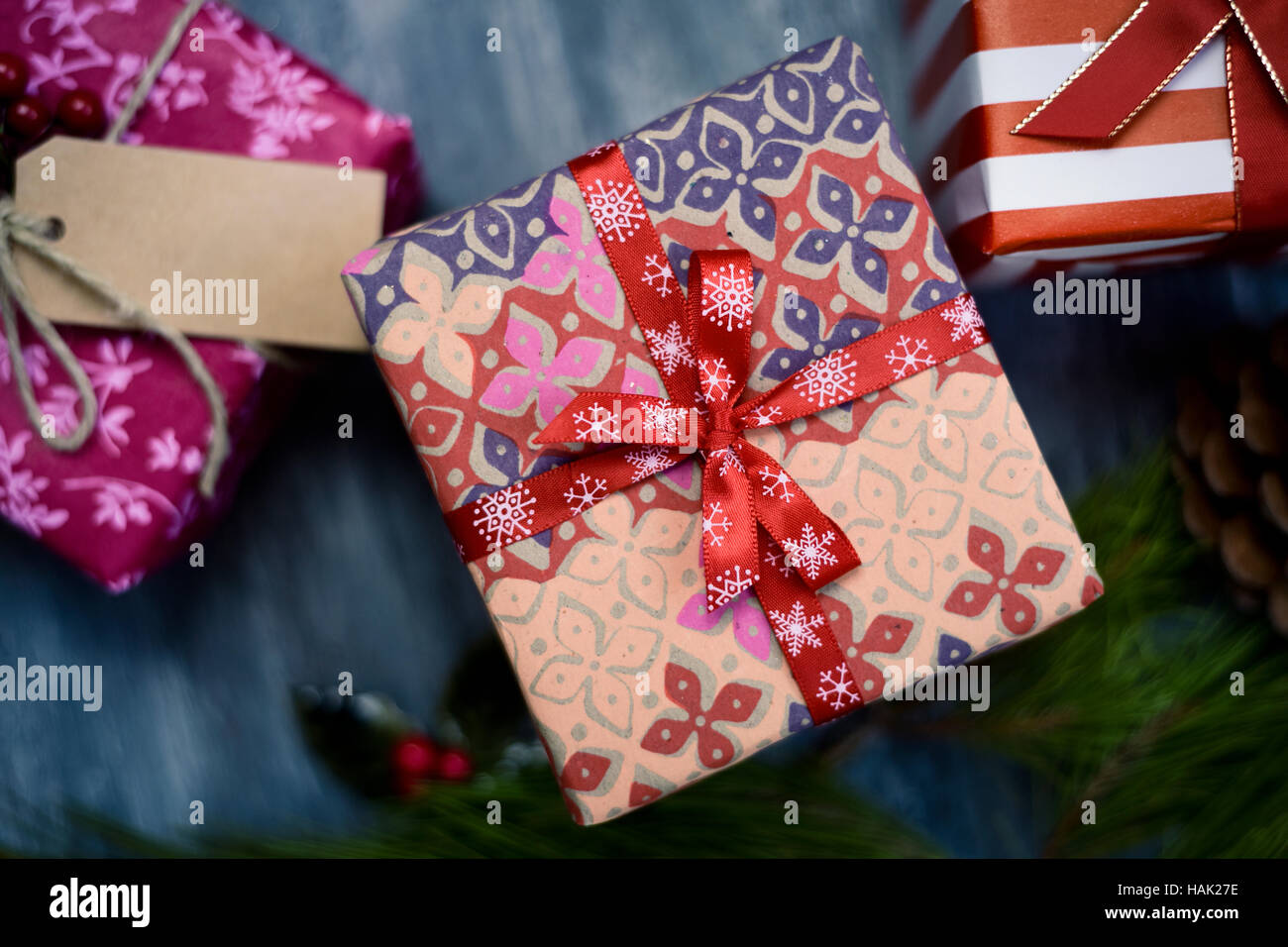 high-angle shot of some cozy christmas gifts wrapped in different nice papers and tied with ribbons and strings of different colors on a rustic wooden Stock Photo