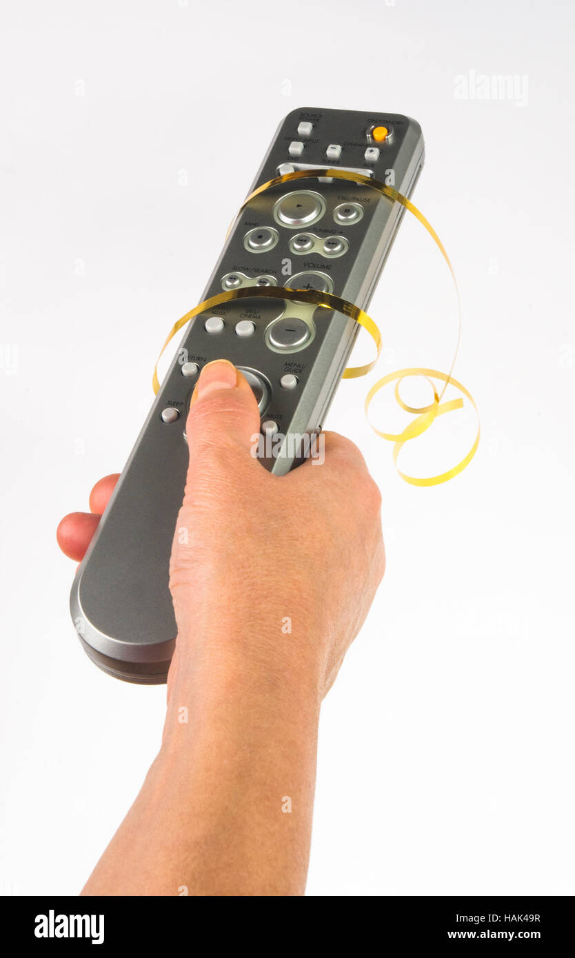 hand holding a remote control in a festive gold ribbon on white