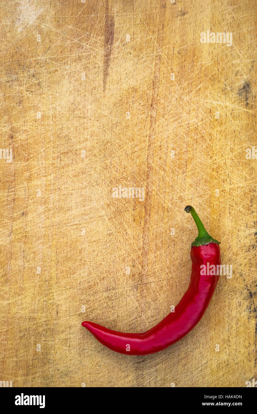 A pod of red hot chili peppers on the old worn wooden background Stock ...