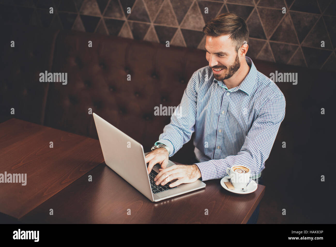 Young man sitting in cafe and using laptop Stock Photo