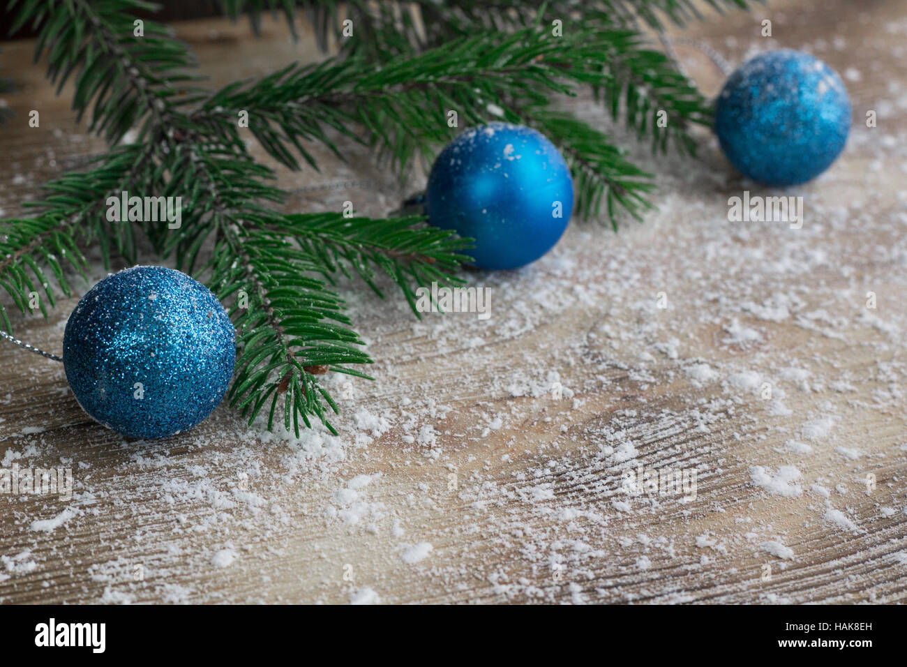 Christmas and New Year winter holiday snowbound wooden space background with green fir tree branches and blue ball ornament Stock Photo