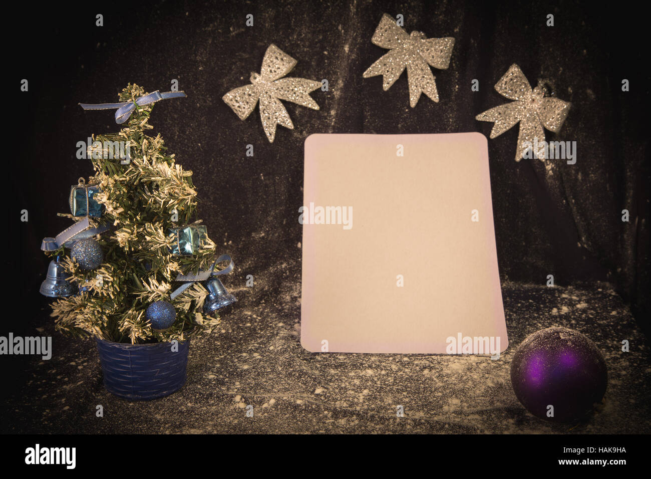 small manmade Christmas tree with toys and bows on wooden and fabric