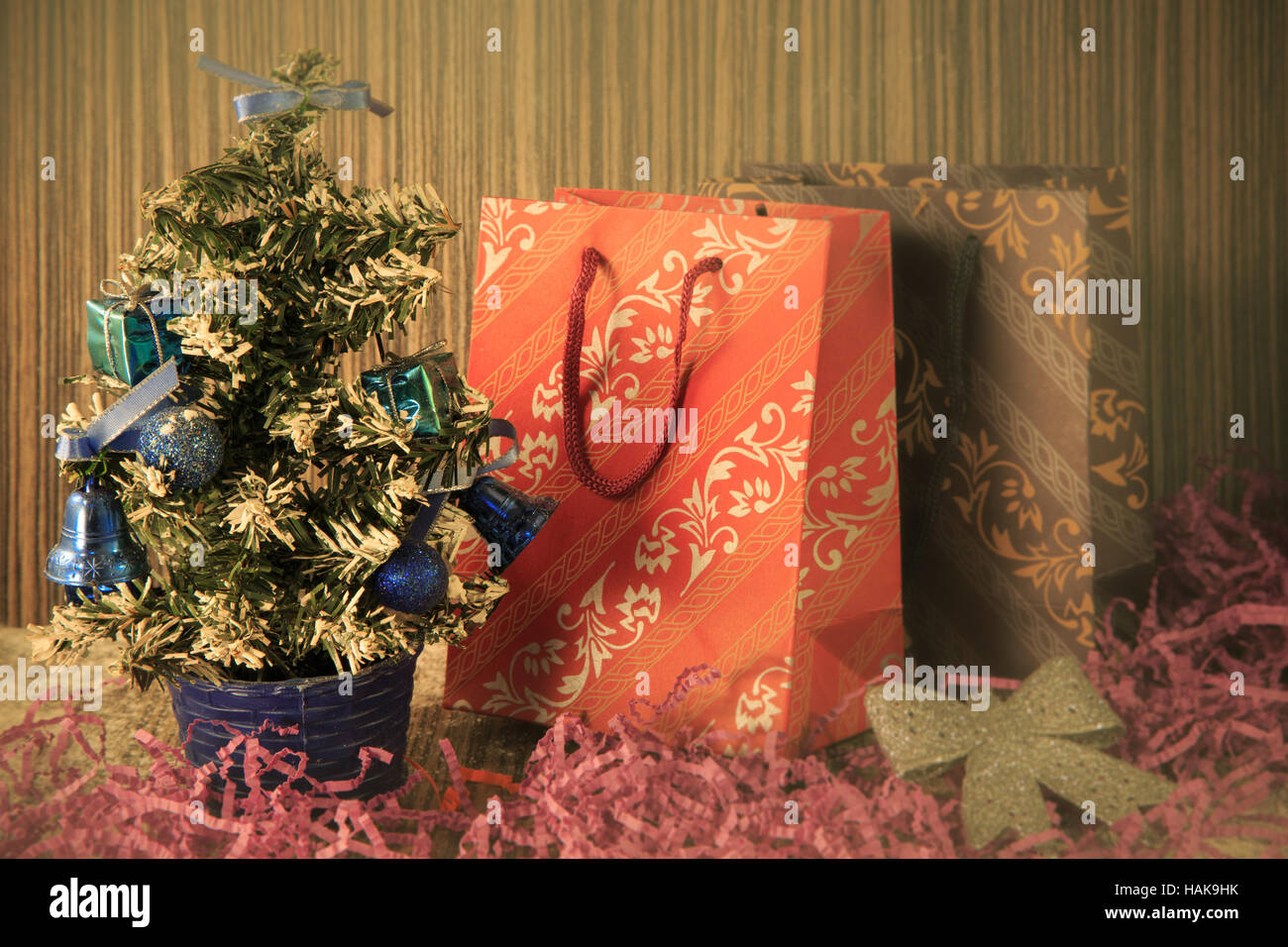 small manmade Christmas tree with toys and bows on wooden and fabric