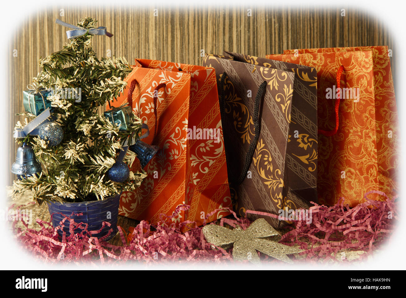 small manmade Christmas tree with toys and bows on wooden and fabric