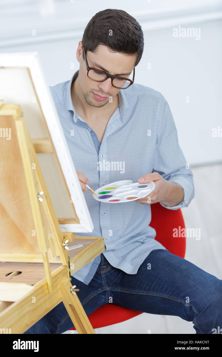 young artist holding a brush and mix on palette Stock Photo - Alamy