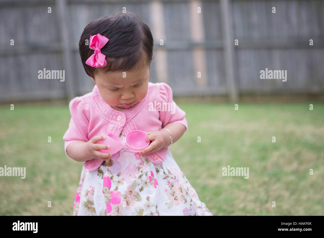 Toddler Girl Frowning as she Opens an Empty Easter Egg Stock Photo