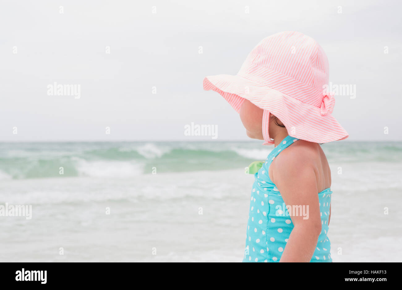 Portrait of Toddler Girl wearing Sunhat on Beach and Looking out at Ocean, Destin, Florida, USA Stock Photo