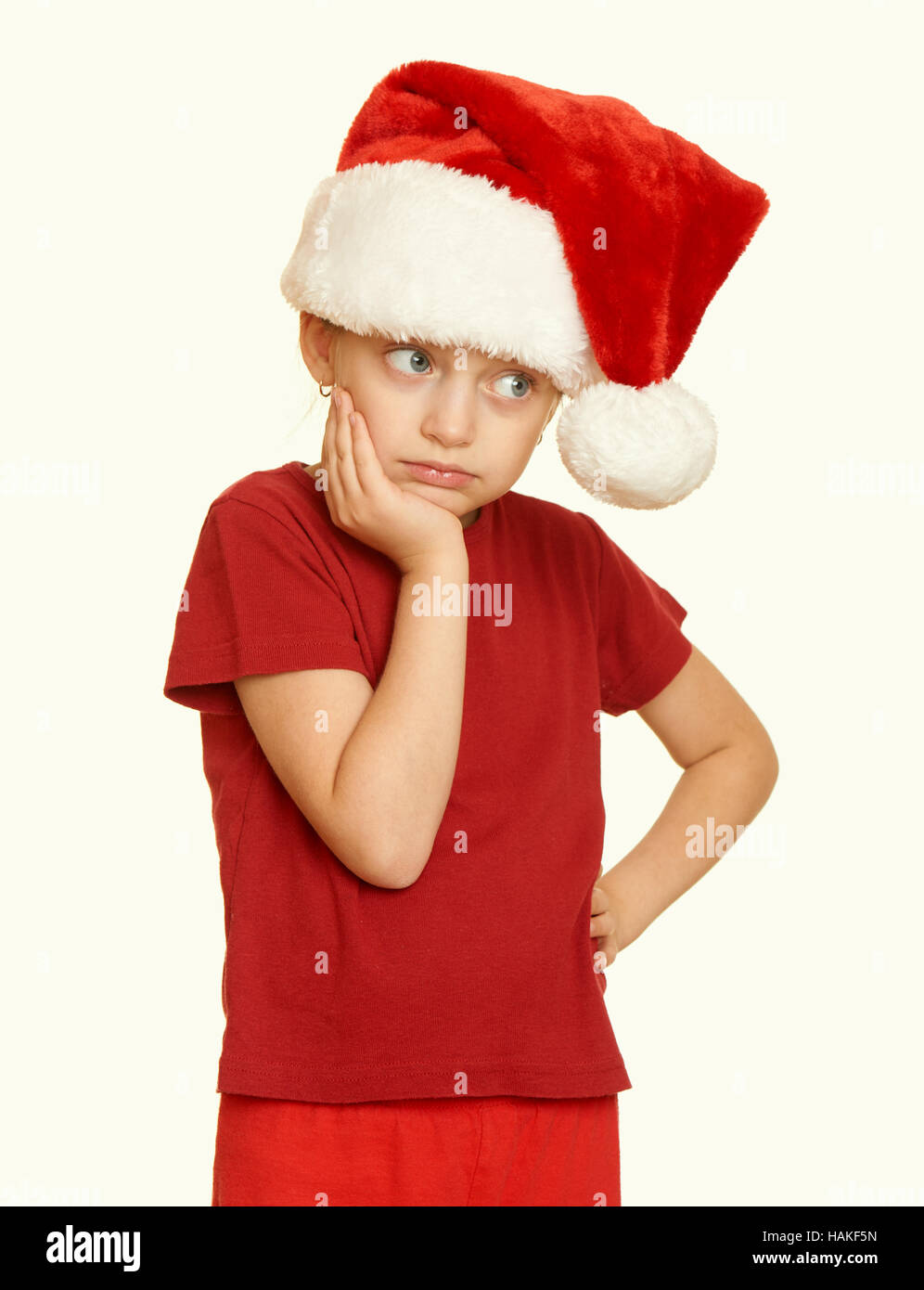 sad girl child in santa hat portrait on white isolated, christmas holiday concept, yellow toned Stock Photo