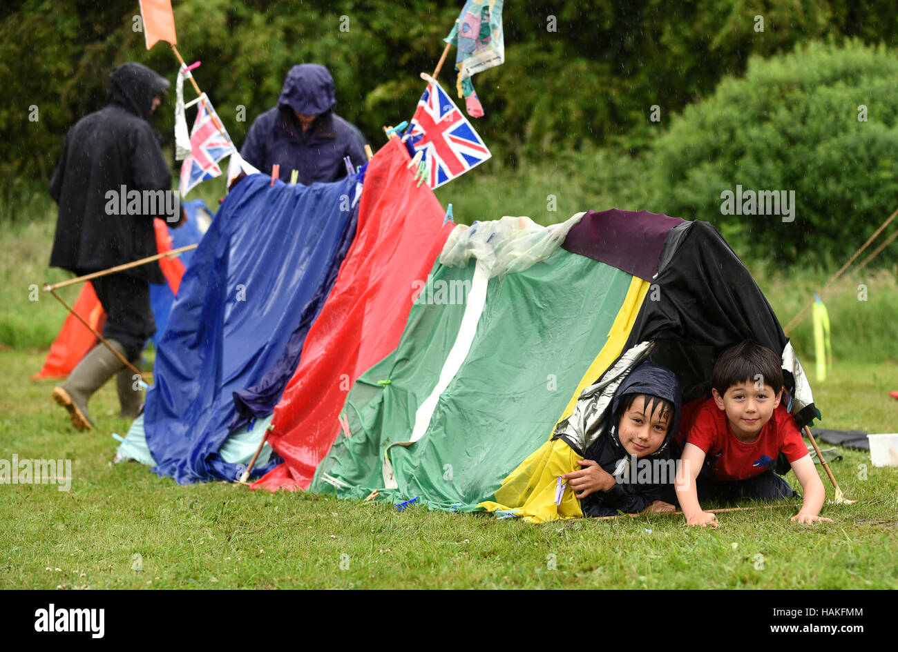 Children camping in home made tent at a wet rainy summer fete Uk Stock Photo