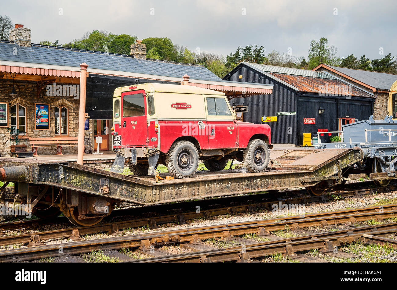 Old Landrover vehicle being transported by rail low-loader freight truck on the South Devon Railway Stock Photo