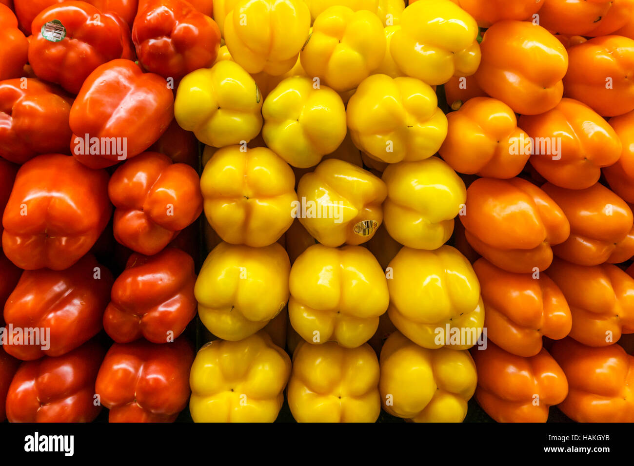 Stacked red, orange and yellow peppers. Stock Photo