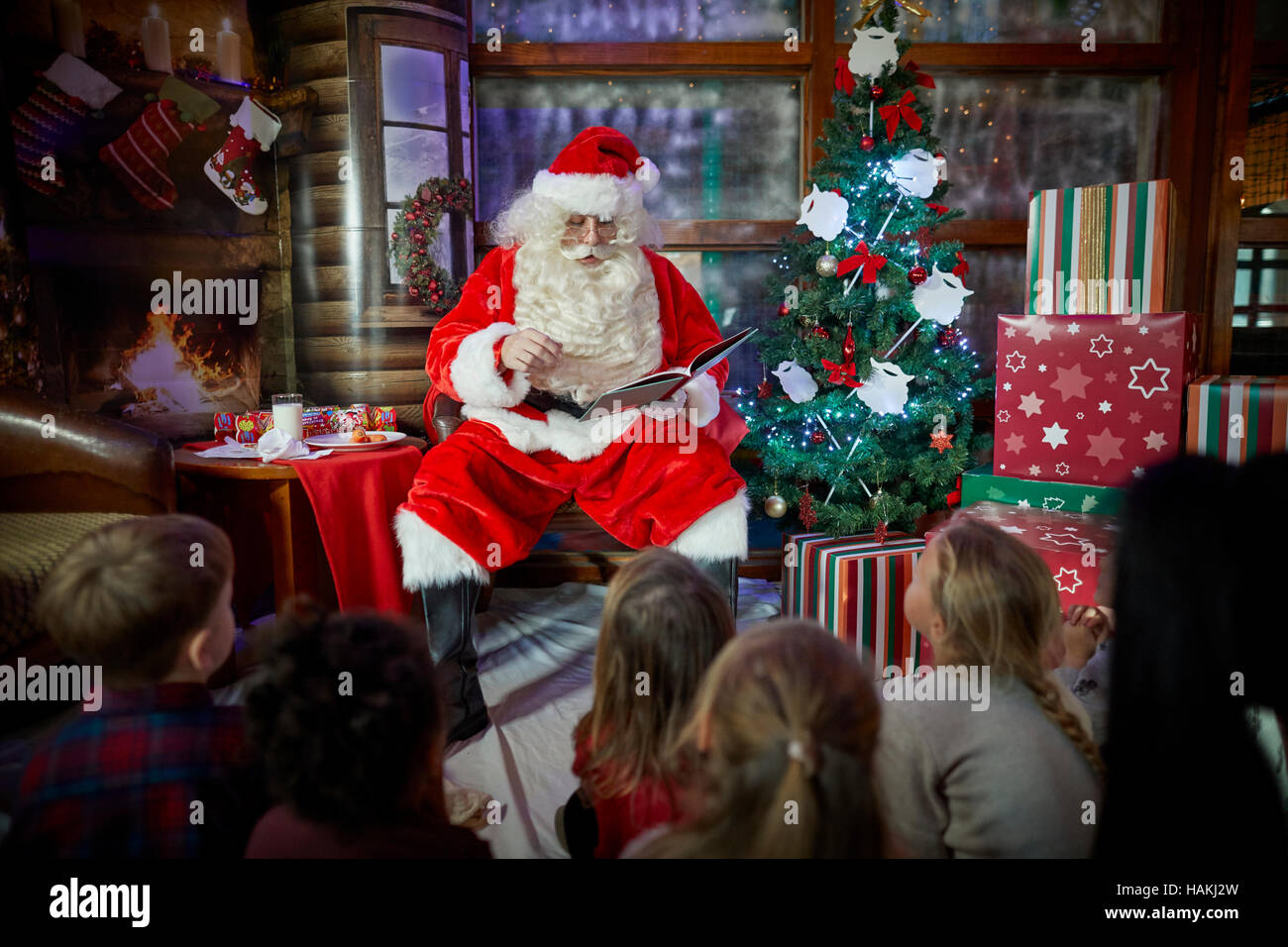 Santa in grotto christmas display lighted christmas tree, presents