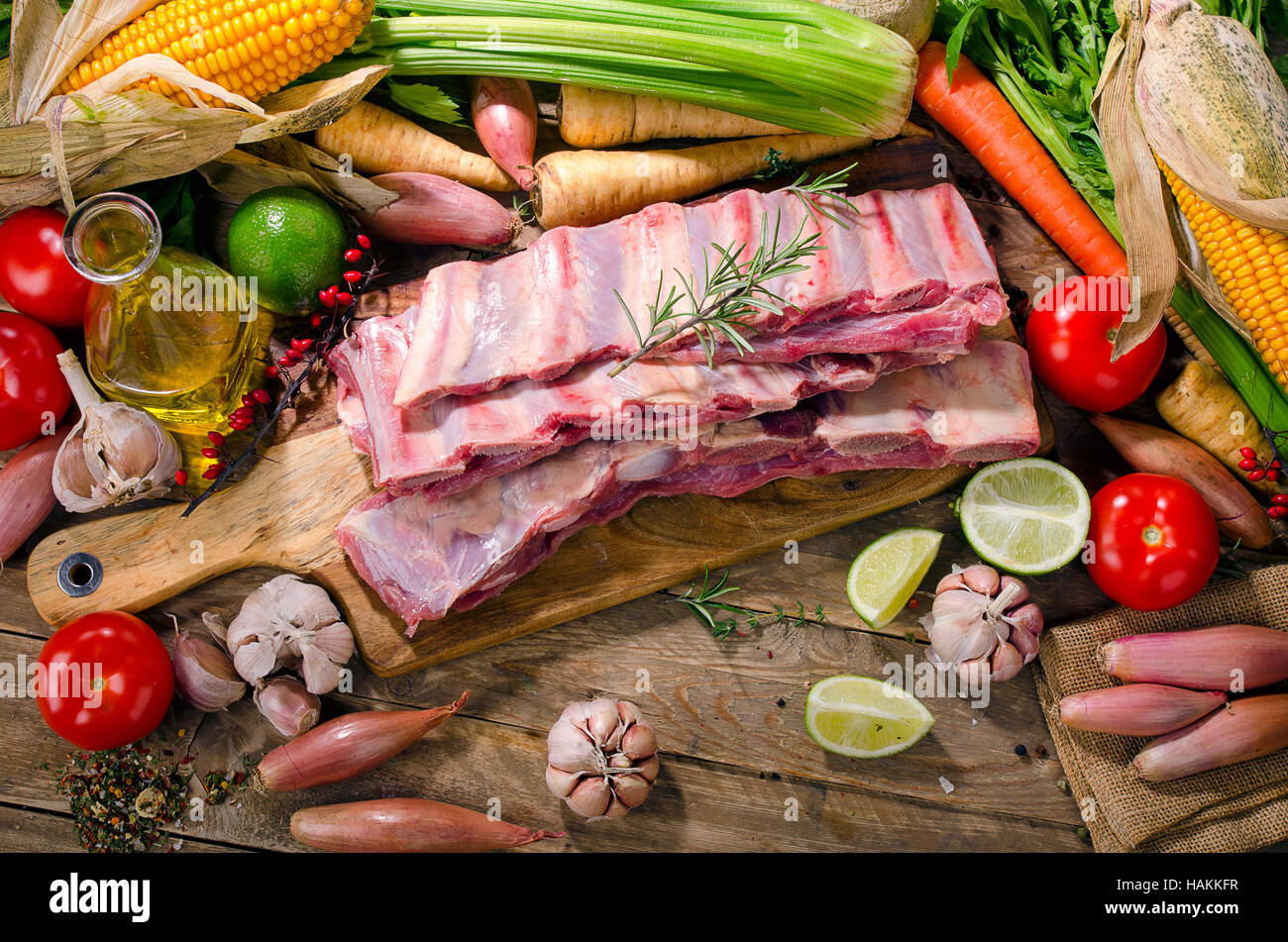 Raw beef ribs and vegetables on  wooden background. View from above Stock Photo