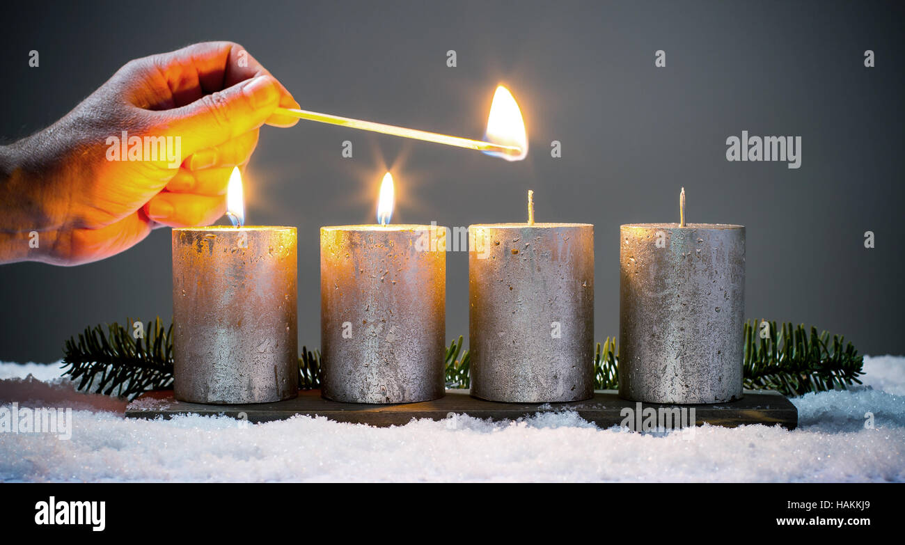 Light four advents candles with matches Stock Photo Alamy