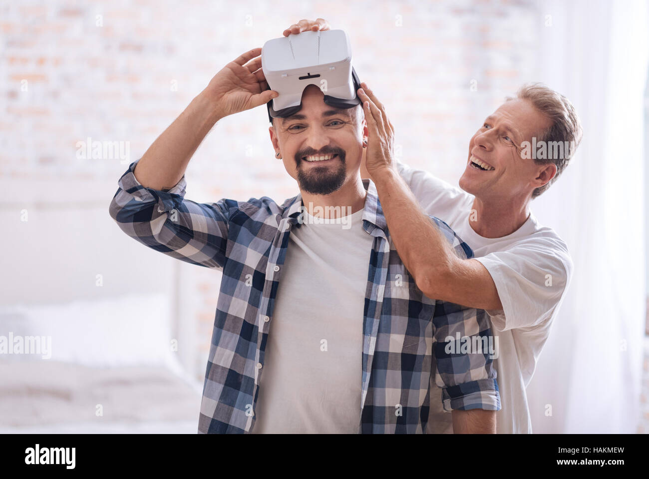 Delighted homosexual couple testing the virtual reality glasses at home Stock Photo