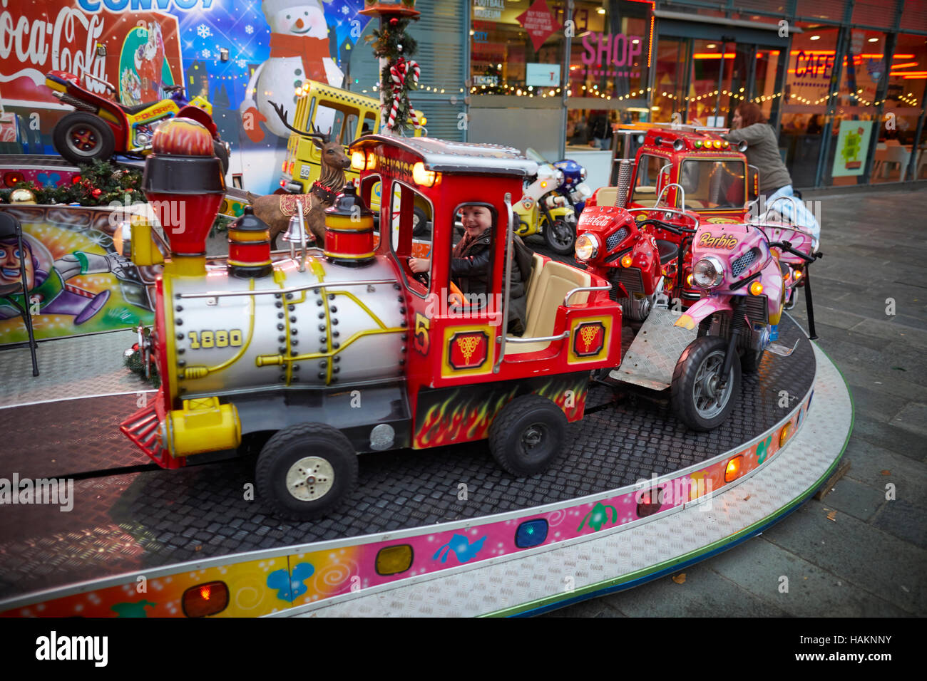 Fair ground ride childrens cars track   Young kids children youngsters child toddlers adolescents small rides pedal cars Christmas winter festive fest Stock Photo